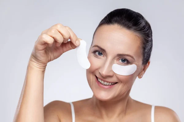 Beauty Treatment Concept Closeup Portrait Middle Aged Woman Applies Patches - Stock-foto