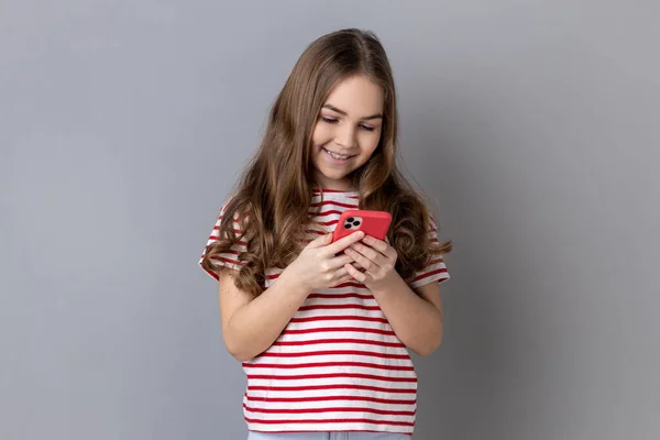 티셔츠를 스마트 사용하여 화면을 아이의 블로그에 소녀의 은회색 배경에 고립되어 — 스톡 사진