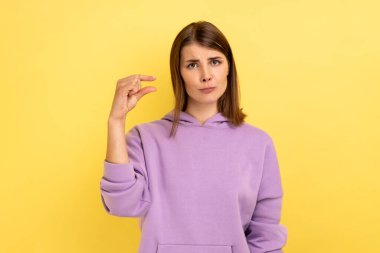 Küçük bir miktar. Çok güzel bir kadının portresi. Elinde küçük bir jest yapıyor ve yalvararak bakıyor. Mor kapüşonlu bir şey giyiyor. Sarı arka planda kapalı stüdyo çekimleri.