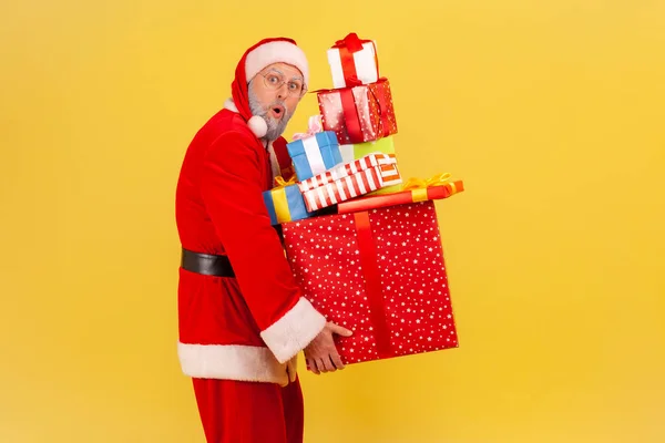 Gri Sakallı Noel Baba Kostümü Giyen Elinde Ağır Hediyeler Tutan — Stok fotoğraf