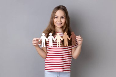 Çizgili tişört giyen, elinde kağıt zincir tutan küçük bir kızın portresi. Çok ırklı insanlar, toplum, birlik, insanlar ve destek kavramı. Gri arka planda izole edilmiş kapalı stüdyo görüntüleri.