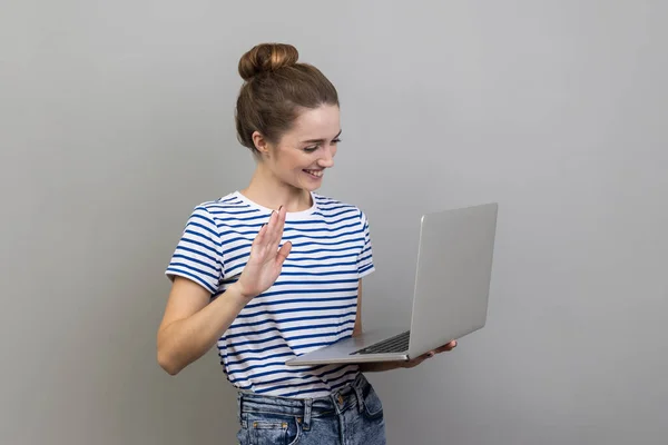 티셔츠를 노트북을 디스플레이를 흔드는 여성의 비디오 전화를 은회색 배경에 고립되어 — 스톡 사진