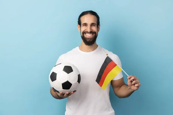 身穿白色T恤衫的笑脸男子形象 在锦标赛 爱国主义等方面支持德国足球队 室内拍摄被蓝色背景隔离 — 图库照片