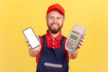 Terfi metni için boş bir ekranla ayakta duran ve akıllı telefon tutan sakallı adamın portresi. Sarı arka planda kapalı stüdyo çekimleri.