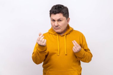 Yakışıklı orta yaşlı bir adamın resmi ayakta ve kameraya parayla bakıyor ya da İtalyan jesti, şehir tarzı kapüşonlu giyiyor. Beyaz arka planda izole edilmiş kapalı stüdyo görüntüleri.