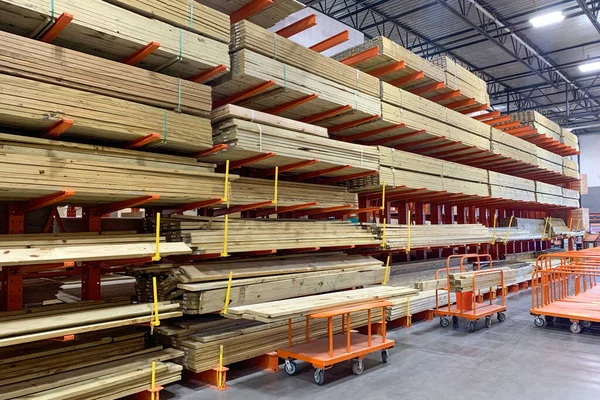 Warehouse with variety of timber for construction and repair on pallets on storage shelves. The factory for the production of laminate. Stacked wood