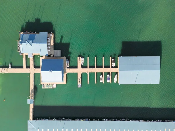 Aerial top down view of boat dock and yacht port, boats are moored on sea. Yacht club boats parking. Photo from drone.