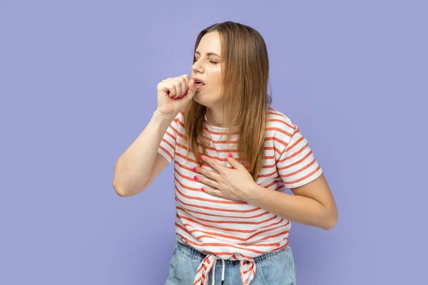 一个病态的不健康金发女人的画像 穿着条纹T恤 肺部疼痛 流感症状 室内拍摄被紫色背景隔离 — 图库照片