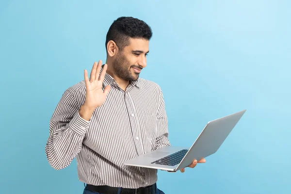 Biznesmen Macha Ręką Witając Się Laptopem Rozmawiając Przez Telefon Kolegą — Zdjęcie stockowe
