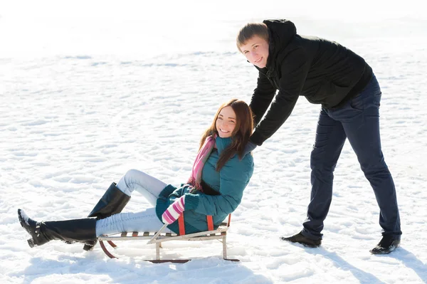 Garçon poussant fille en luge — Photo