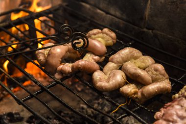 İnek bağırsakları ahşap bir tahtanın üzerinde malzemelerle sunuluyor, ızgaraya hazır.