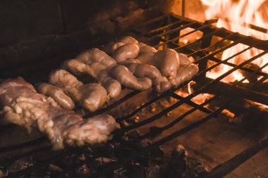 İnek bağırsakları ahşap bir tahtanın üzerinde malzemelerle sunuluyor, ızgaraya hazır.
