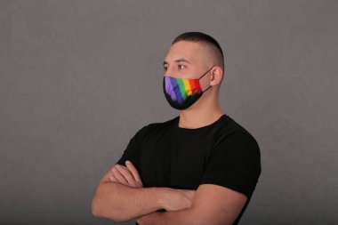lgbt sembollü tıbbi maskeli genç bir adam. Homoseksüel yakın plan portre