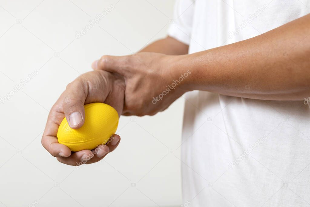 Hands of asian male holding a stress ball,man patient doing hand and wrist exercise,training with rubber ball,squeezing for muscle strength,treatment of hand finger weakness,physical therapy,recovery