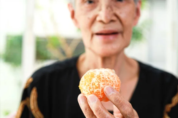 手里拿着有机橙的老年人 健康的老年妇女展示果皮桔子或橘子皮 橙色纤维中的维生素C 健康食品 营养观念 — 图库照片