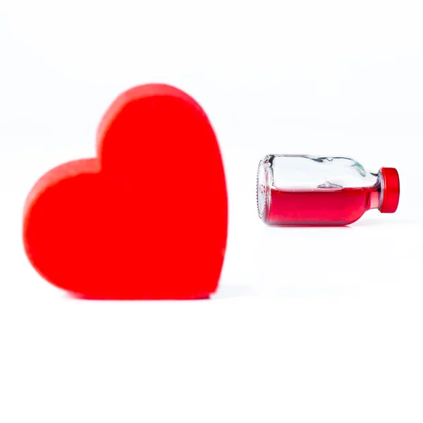 Kolby szklane wypełnione żywy czerwony płyn z modelu serca — Zdjęcie stockowe