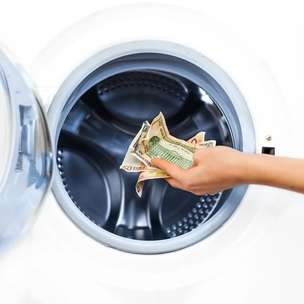 Έννοια του εγκλήματος του πλυντηρίου χρήματα: λεπτομέρεια ενός χεριού βάζοντας χρήματα Εικόνα Αρχείου