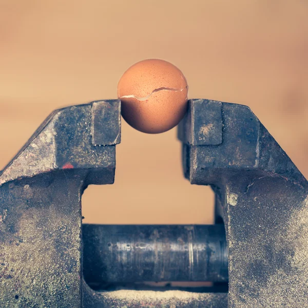 An Egg Cracking under Pressure from Vice (color toned Image) — Stock Photo, Image