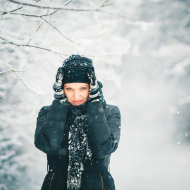 Genç ve güzel kadın kendini kar yağışı koruyor