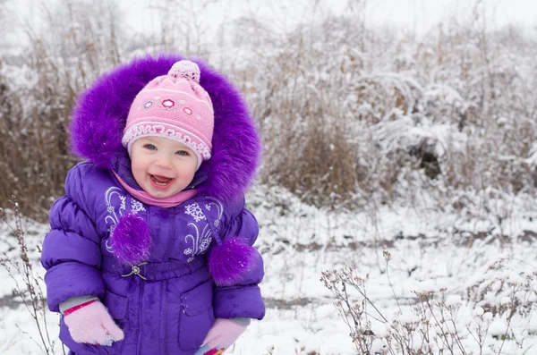 Porträt eines glücklichen kleinen Mädchens in verschneiter Landschaft lizenzfreie Stockfotos