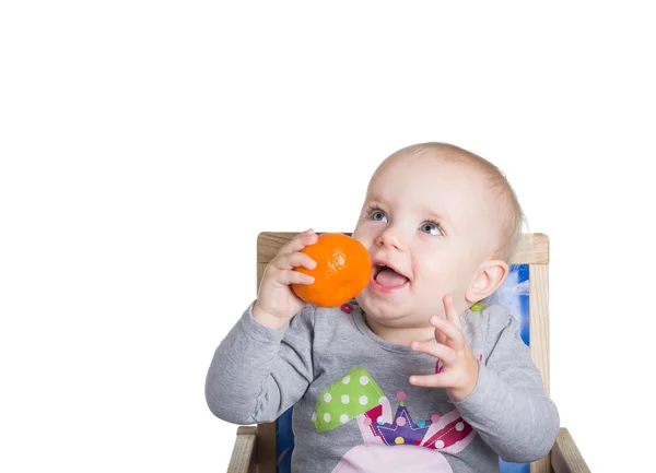 Child with an orange looks up — Stock Photo, Image
