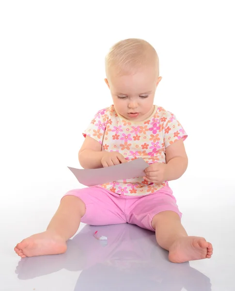 Baby spielt mit einem Bild auf weißem Hintergrund — Stockfoto