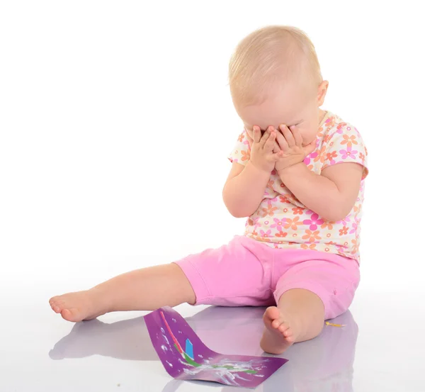 Bebê brincando com uma imagem no fundo branco — Fotografia de Stock