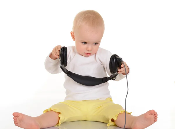 Baby playing with headphones on white background — Stock Photo, Image