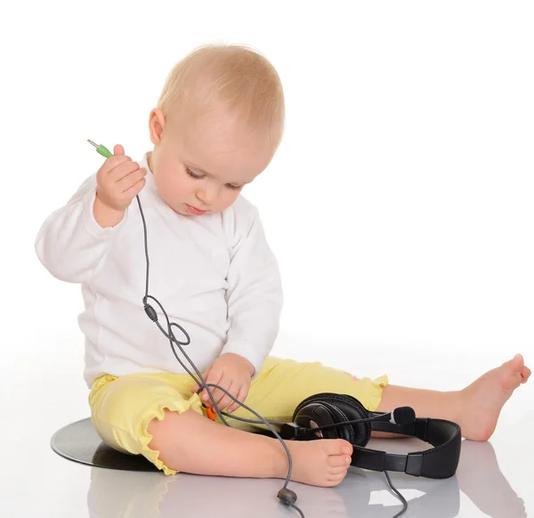 Baby playing with headphones on white background — Stock Photo, Image