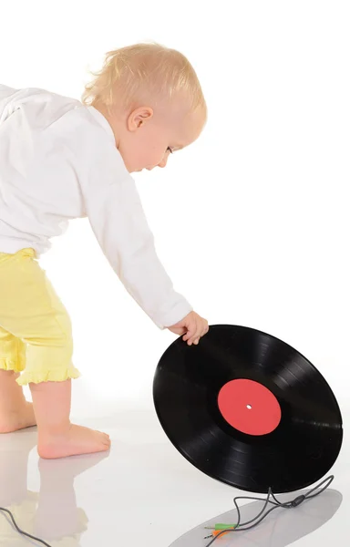 stock image baby playing with old vinyl record on white background
