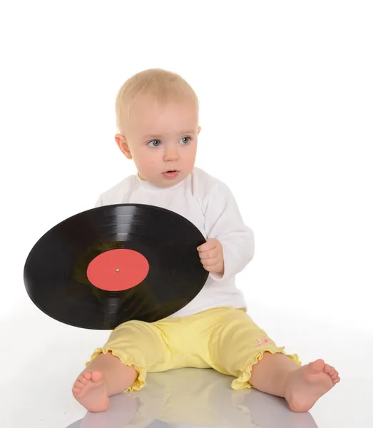 Bonito bebê jogar com idade vinil registro no branco fundo — Fotografia de Stock