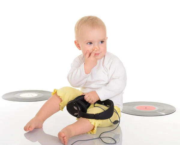 Bebé jugando con viejos discos de vinilo y auriculares en respaldo blanco —  Fotos de Stock