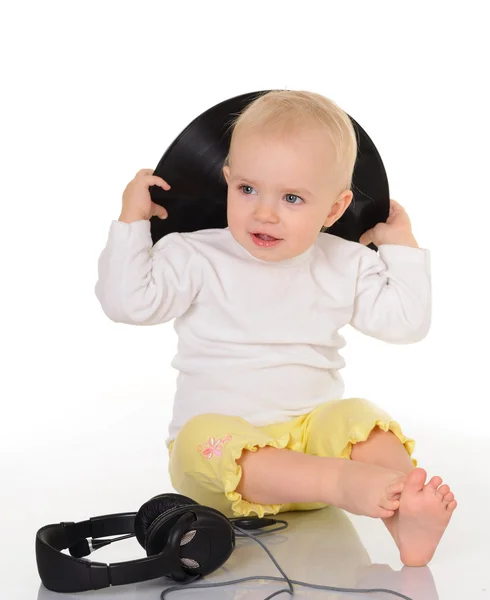 Baby playing with old vinyl record and headphones on white backg — Stock Photo, Image