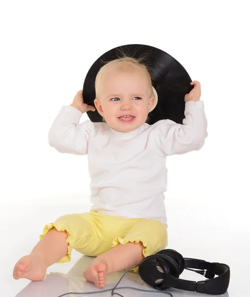 Bebé jugando con viejos discos de vinilo y auriculares en respaldo blanco —  Fotos de Stock