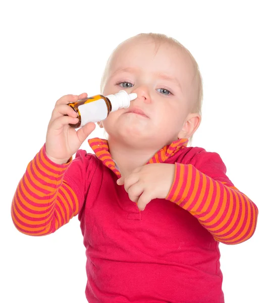 Pequena menina pulverizando-se pulverizador de nariz isolado no branco b — Fotografia de Stock