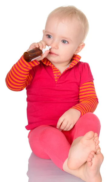 Little baby girl spraying herself nose spray isolated on white b — Stock Photo, Image