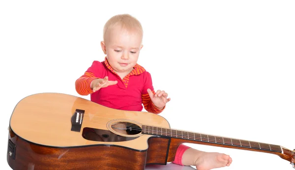 Pequeno músico bonito tocando guitarra no fundo branco — Fotografia de Stock