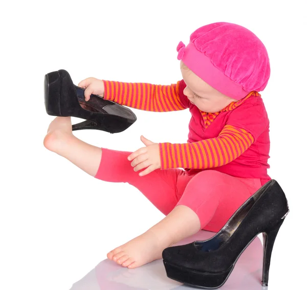 Bonito pouco bebê menina tentando no ela mãe 's sapatos no branco de volta — Fotografia de Stock