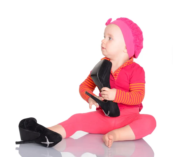 Bonito pouco bebê menina tentando no ela mãe 's sapatos no branco de volta — Fotografia de Stock