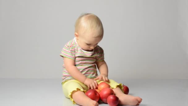 Baby spielt mit Äpfeln — Stockvideo