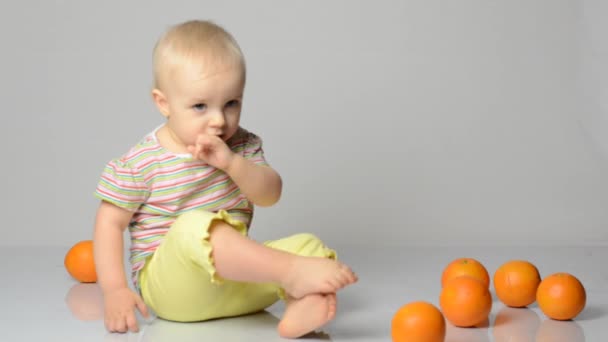 Baby spielt mit Orangen — Stockvideo