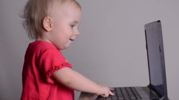 Cute baby girl using a laptop computer. Rack focus and dolly in. — Stock Video