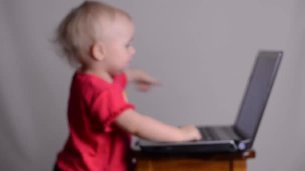 Cute baby girl using a laptop computer. Rack focus and dolly in. — Stock Video