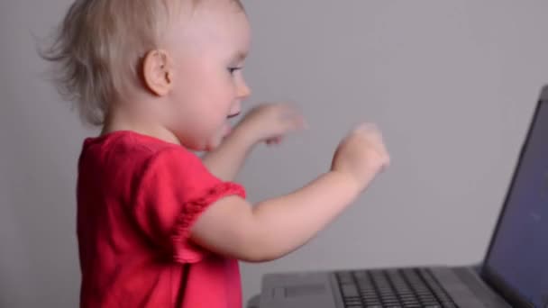 Cute baby girl using a laptop computer. Rack focus and dolly in. — Stock Video