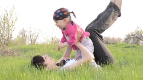 Familie speelt op het gras, de moeder en de baby — Stockvideo