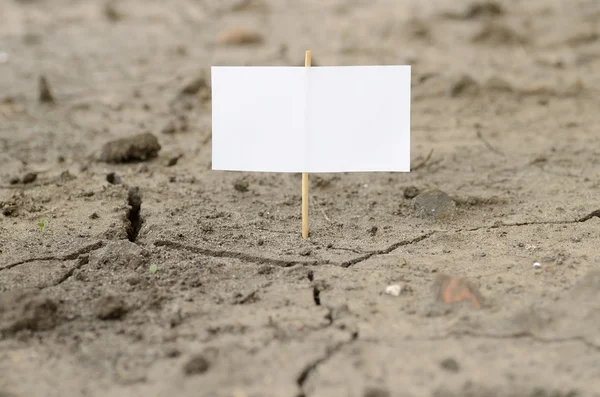 Cartello vuoto su un terreno incrinato — Foto Stock