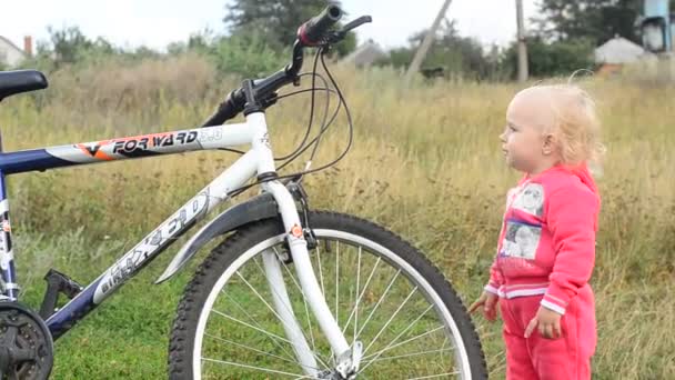 Niedliches Baby probieren großes Fahrrad. — Stockvideo
