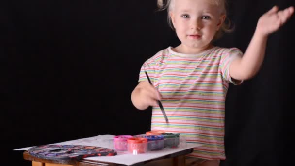 Cute little baby painter on black background. — Stock Video
