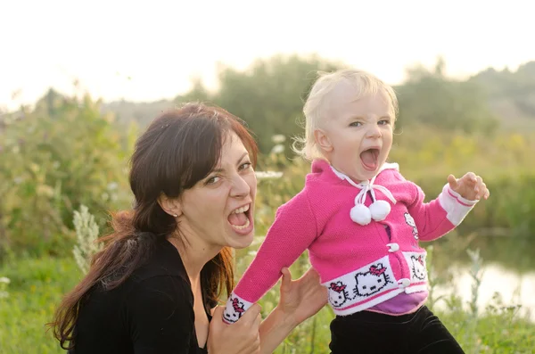 Happy young mother and child having rest near the river — Stock Photo, Image