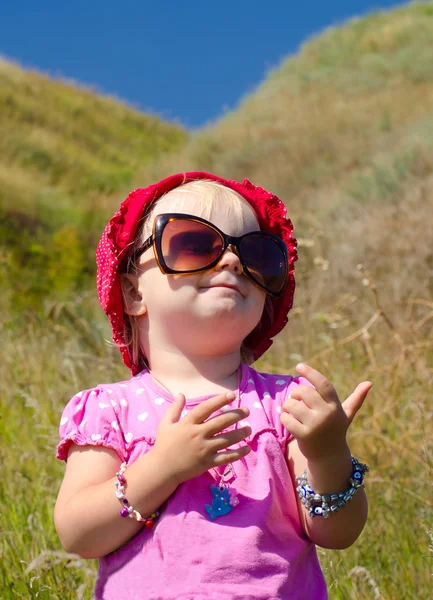 Tepenin arka plan üzerinde poz güneş gözlüklü şirin bebek — Stok fotoğraf